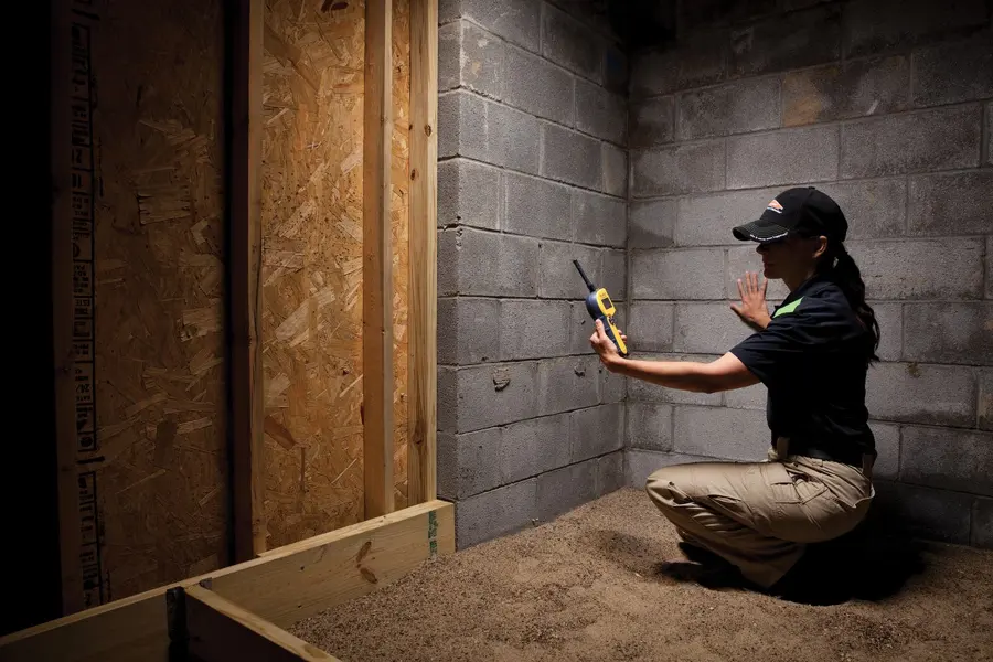 A technician checking a wall for moisture in Des Plaines